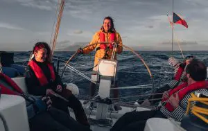Boating course quiz participants learning sailing skills in the cockpit and at the helm